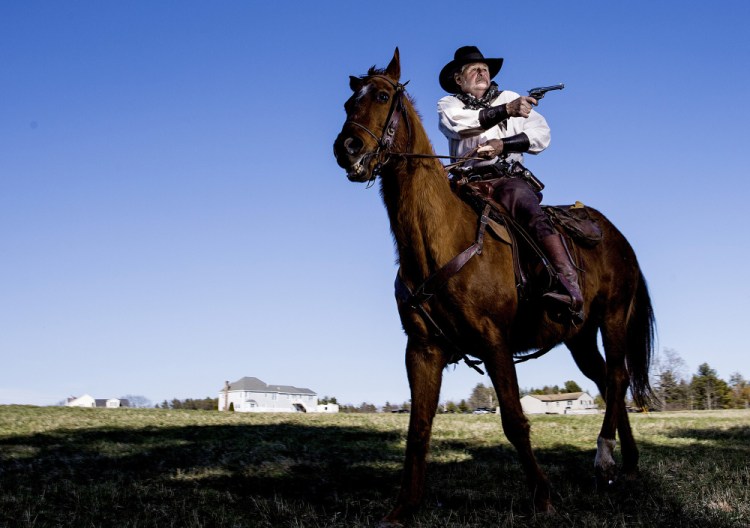 Bill Ledoux, president of the Maine Mounted Cowboy Shooters, poses at his Biddeford home last month with his registered quarter horse Teddy.