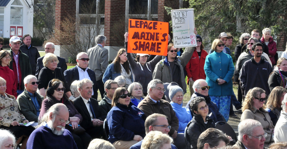 Students Allyson Hammond, left, and Nickolas Bray display protest signs that led Gov. Paul LePage to walk out of a UMaine-Farmington event Tuesday and call them "idiots."