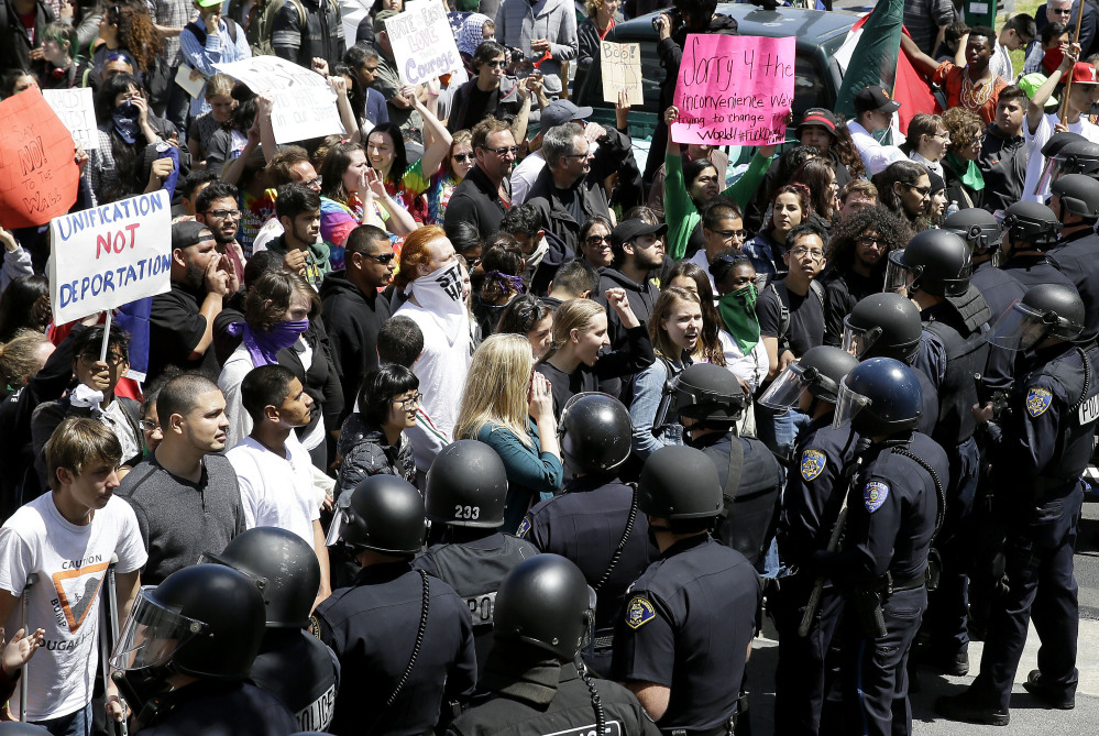 Police officers form a line in front of protesters outside the hotel where Republican presidential candidate Donald Trump was speaking to the California Republican Party 2016 convention in Burlingame, Calif., on Friday.