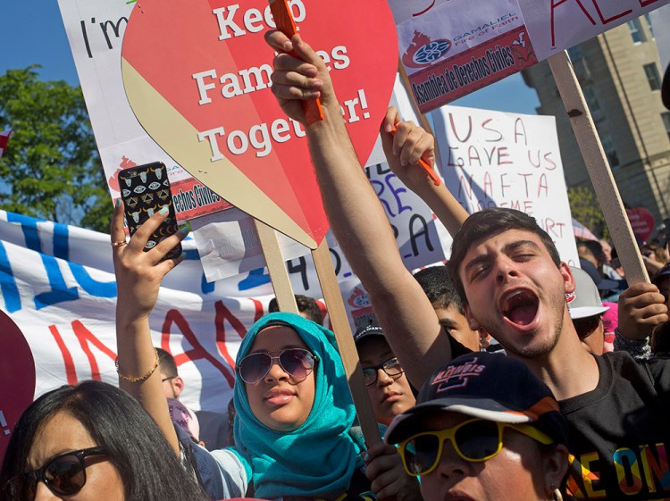 Supporters of immigration reform gather in front the Supreme Court in Washington Monday, as the Obama administration asks the justices to allow two programs that could shield roughly 4 million people from deportation and make them eligible to work in the United States. The Associated Press