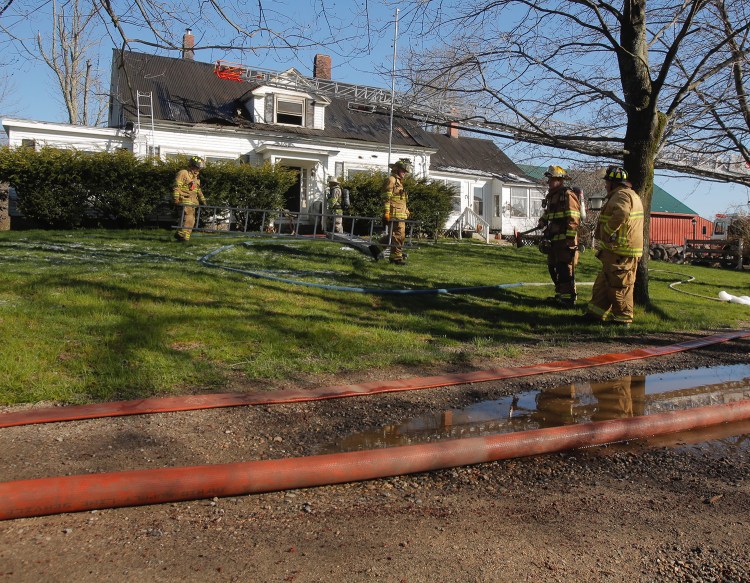 Firefighters clean up after fighting a fire on Grammar Road in Sanford on Wednesday morning. 