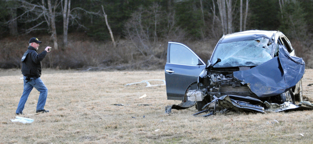 An investigator records the wreckage of a car involved in a fatal crash March 18 in the town of Washington. The trucker who crossed the center line has been indicted on two counts of manslaughter.