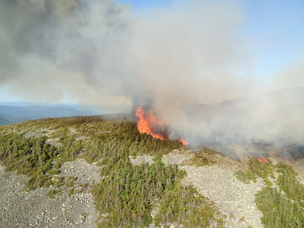 Fire burns at the summit of Mount Abram, in Franklin County, over the weekend. Crews had made progress by Tuesday but expected the effort still to take several days before the fire is completely out.