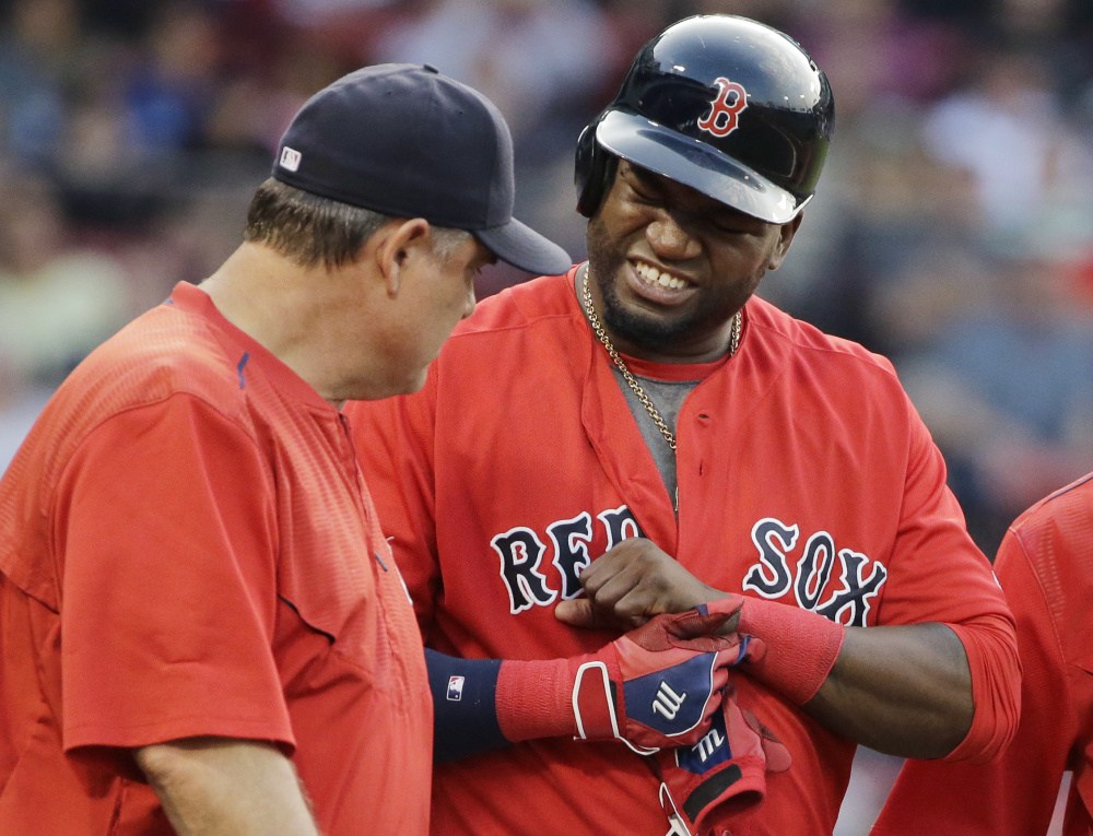 Red Sox designated hitter David Ortiz grimaces while showing Red Sox Manager John Farrell where he got hit by a pitch in the first inning.