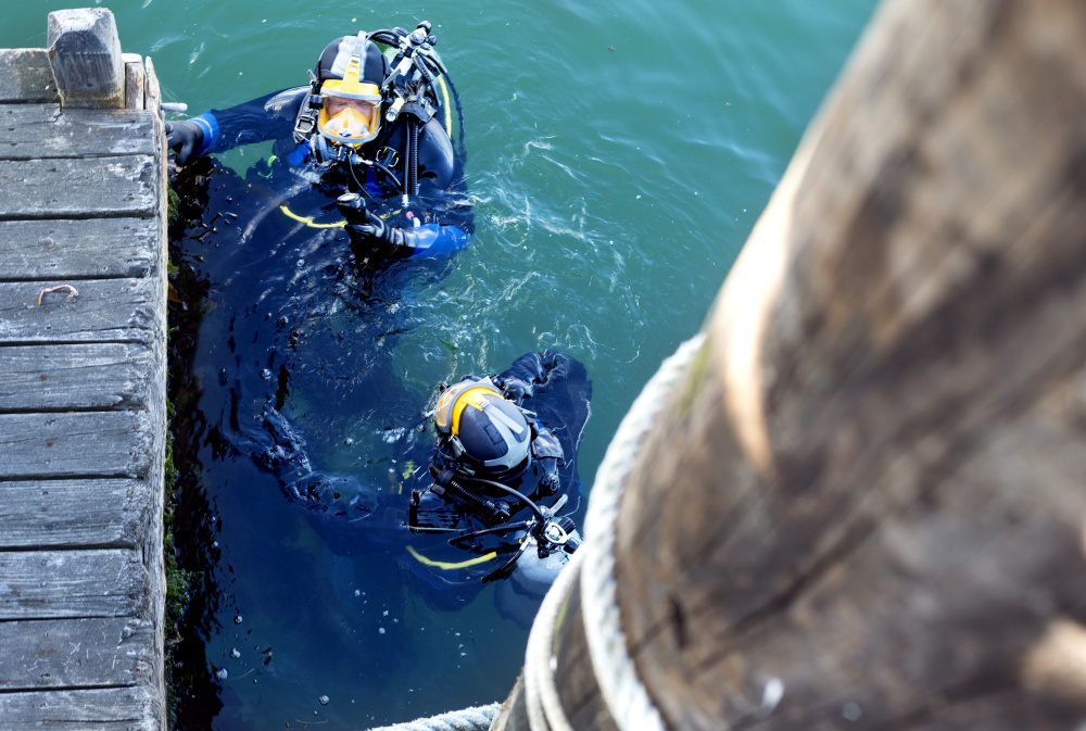 Divers prepare to search under Widgery Wharf in Portland for Matthew Foster, 23, of Scarborough, missing since Friday.