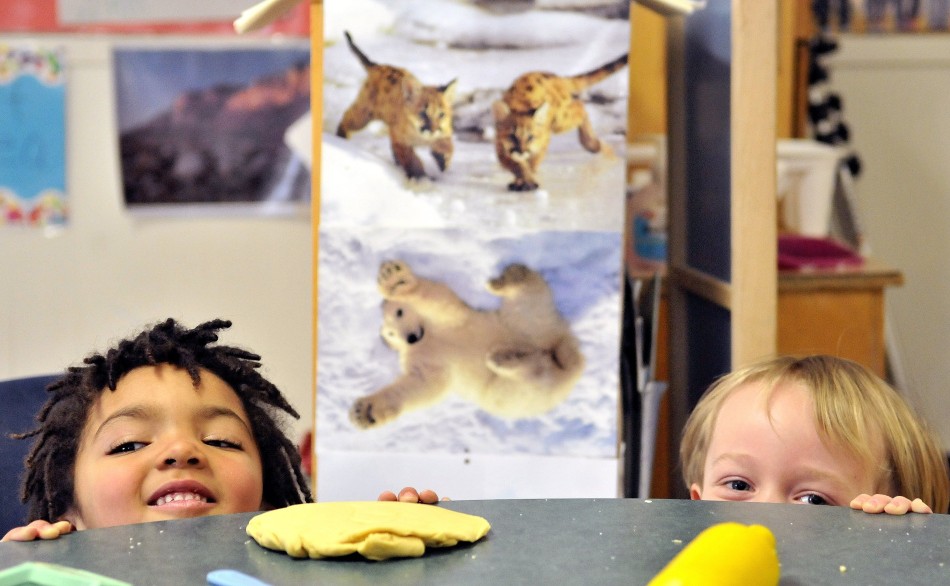 Mckyah Pooler, 3, left, and Devon Wilbur, 4, play peek-a-boo during preschool activities at the Maine Children's Home for Little Wanderers in Waterville. Maine preschool teachers earn slightly over the U.S. median.