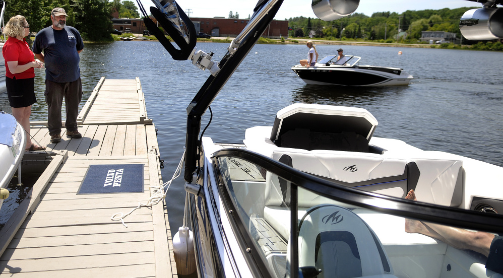 Nelson Lavigne inspects a boat with Pauline Gagnon at the docks on Maranacook Lake in Winthrop on Sunday, where fathers were offered a boat ride in exchange for a donation to a cat shelter in Winthrop.