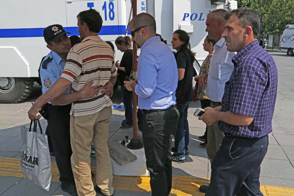 A Turkish policeman, left, searches men at the entrance of the courthouse where prosecutors are questioning several generals, including an ex-Air Force commander suspected of being coup ringleader, in Ankara, Turkey, on Tuesday.