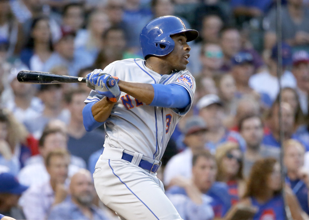 Curtis Granderson of the Mets hits a sacrifice fly off Chicago Cubs starting pitcher Jake Arrieta, scoring Jose Reyes, during the sixth inning of Tuesday's game, won by the Mets in Chicago.