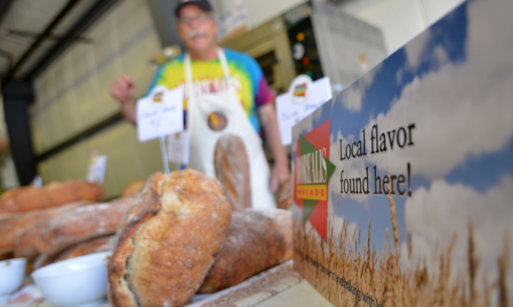 Jim Amaral prepares an assortment of bread at his Borealis Breads table at the Maine Artisan Bread Fair at the Skowhegan Fair Grounds on Saturday.