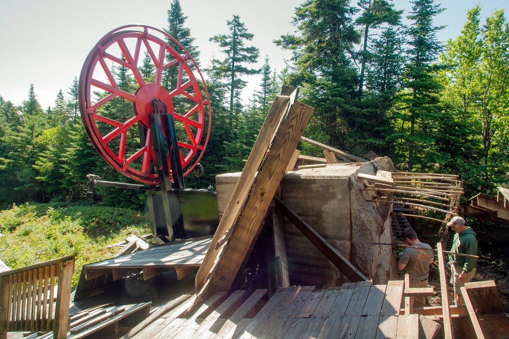 Men inspect the wreckage of the top unloading terminal of the resort's Spruce Peak Triple ski lift on Monday. Nick Lambert/Sunday River via AP