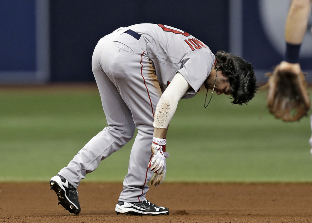 Boston's Andrew Benintendi tries to get to his feet after injuring his leg in a double play in the seventh inning Wednesday night in St. Petersburg, Fla. Benintendi left the game.