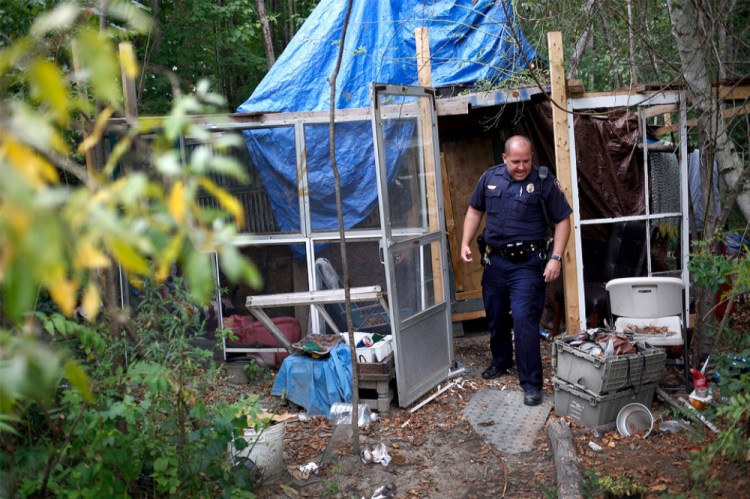 Community policing Sgt. Andrew Hutchings makes rounds Wednesday at the homeless encampment on the outskirts of Portland, where he gave remaining occupants one more day to move out.
