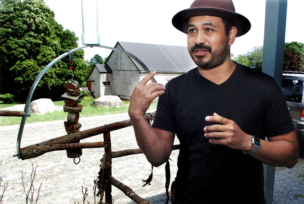 Standing beside a homemade bird perch at the Skowhegan School of Painting and Sculpture in East Madison on Monday, Oscar Cornejo speaks about his escaped parrot Paco that he has been searching for since the bird flew away Thursday.