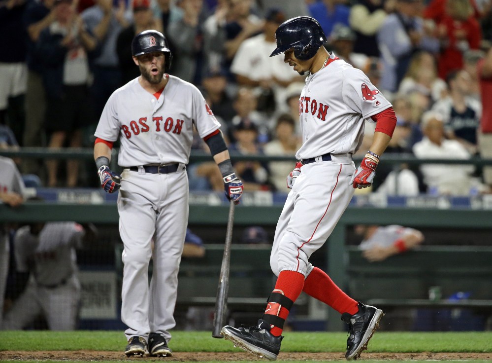 Mookie Betts touches home plate on his game-winning home run in the ninth inning Monday night in Seattle.