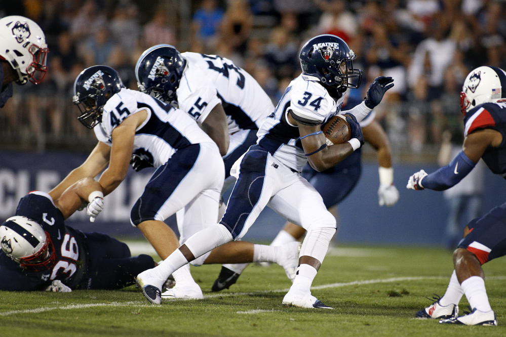 UMaine running back Josh Mack slides past his blockers for first-down yardage during Thursday's college football game at Rentschler Field in East Hartford, Conn.