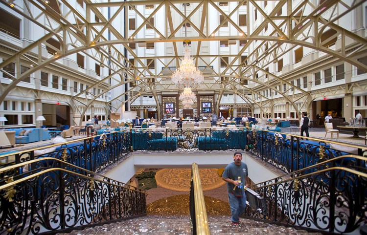 Workers apply finishing touches to the grand concourse of Trump International Hotel during its "soft opening" in downtown Washington last September. 