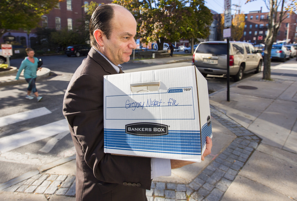 Matthew Nichols, defense attorney for landlord Gregory Nisbet, carries papers into the Cumberland County courthouse Wednesday. Nichols will start putting on his case Thursday.