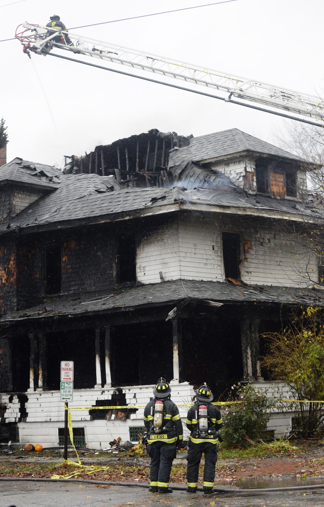 Firefighters work the scene on the day of the fire. How the building was operated has been a focus of the landlord's manslaughter trial.