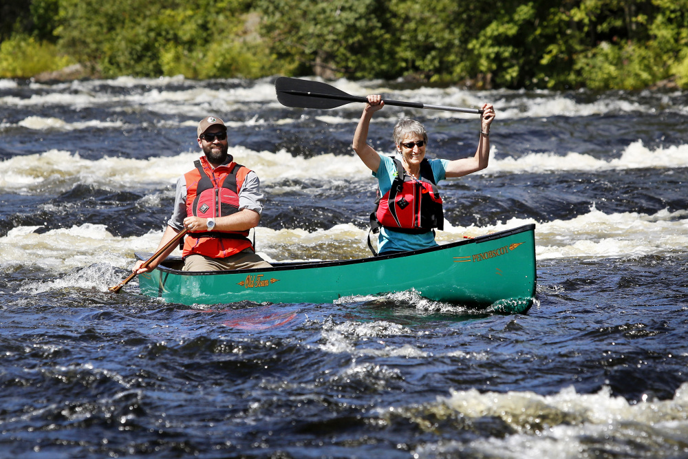 Interior Secretary Sally Jewell raises her paddle Aug. 27 after "running" Staircase Falls on the East Branch of the Penobscot River with Lucas St. Clair during a tour of the Katahdin Woods and Waters National Monument. Since the Aug. 24 announcement that the monument had been created on land donated by St. Clair, his mother and their family, traffic on the monument's main loop road has almost tripled.