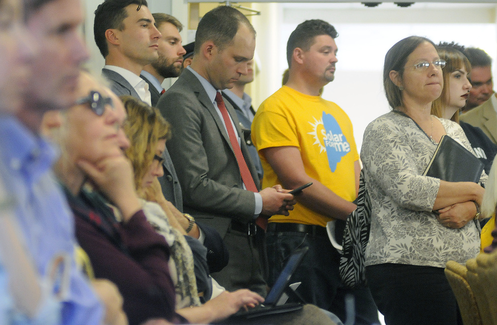 People wait to testify Monday at a Maine Public Utilities Commission hearing in Hallowell on the agency's proposal to phase out financial incentives for homeowners with solar panels who feed electricity into the grid. The Legislature may have the final say after it convenes in 2017.