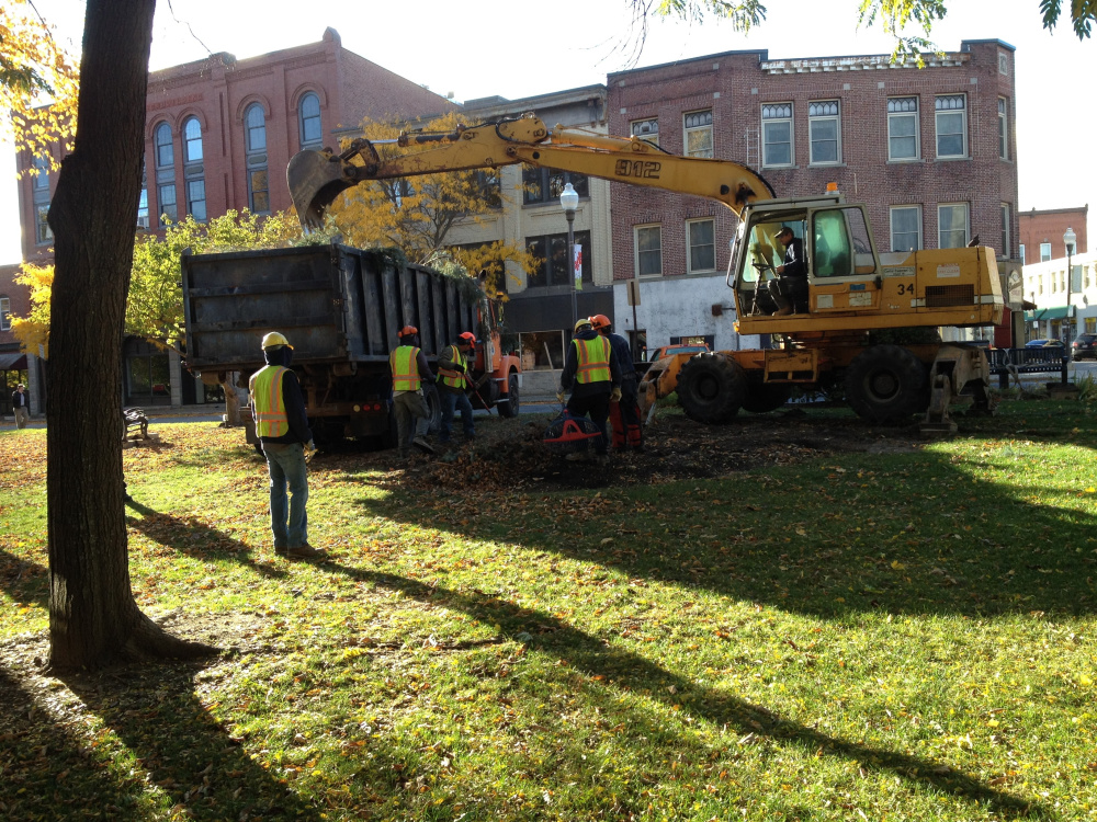 The remains of a giant blue spruce tree in Castonguay Square in downtown Waterville is removed by city workers early Tuesday morning. Officials said about half of the tree was diseased.