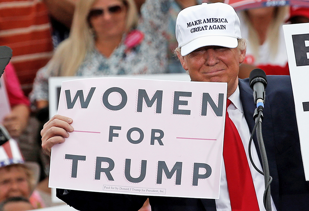 Republican presidential candidate Donald Trump holds up signs at the end of a campaign rally in Lakeland, Florida, on Wednesday. <em>Mike Segar/Reuters</em>