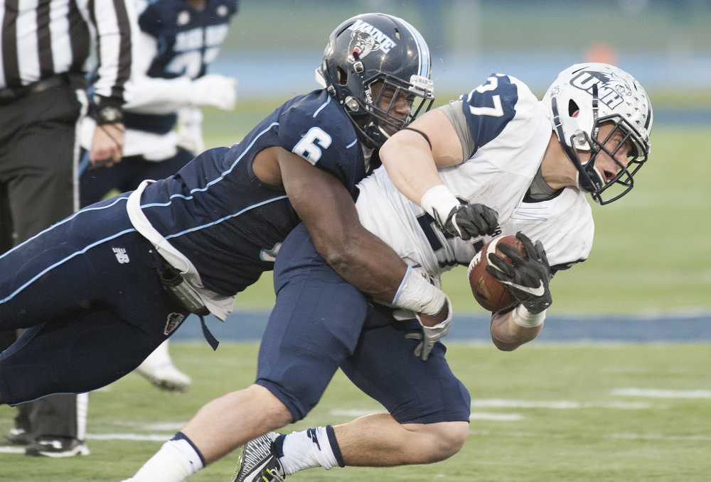 Christophe Mulumba Tshimanga of Maine brings down Dalton Crossman of New Hampshire during the second half of New Hampshire's 24-21 victory Saturday at Orono.