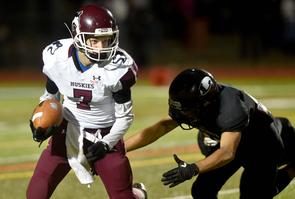 MCI quarterback Josh Buker scrambles for extra yards during the Class D state championship game Saturday night at Fitzpatrick Stadium. Buker directed a second-half comeback as the Huskies pulled out a 20-14 win.