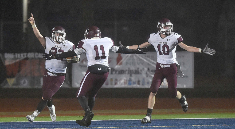 Eli Bussell, left, of Maine Central Institute celebrates after he scored a last-second touchdown to beat Lisbon 20-14 in the Class D state championship game Saturday night at Fitzpatrick Stadium in Portland.