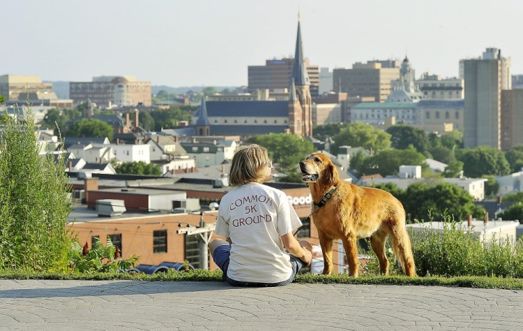 Blair Atherton enjoys the view of the city with her dog, Mango, at the overlook on the Fort Sumner Park Trail on Munjoy Hill last November.