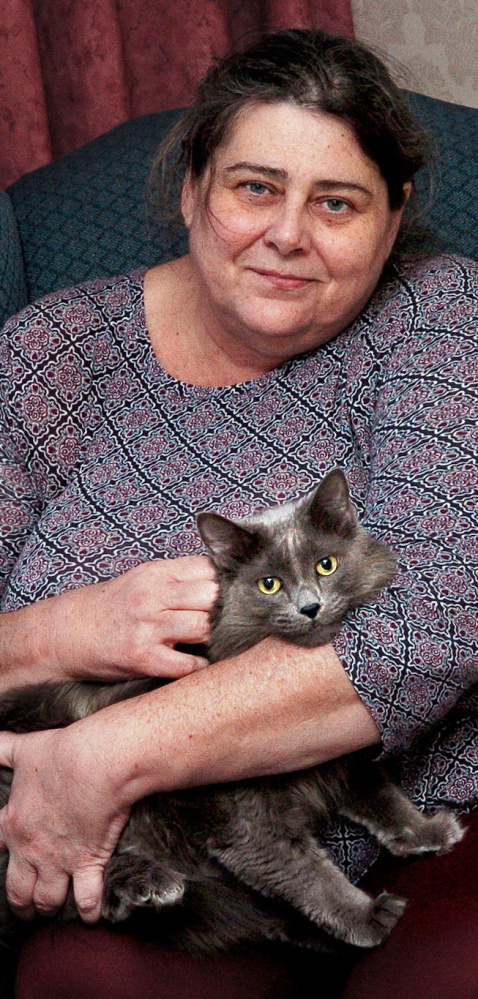 Cheryl Jack keeps her cat, Oliver Grey, close to her Tuesday. They they are reunited after a fire in their apartment on Saturday.