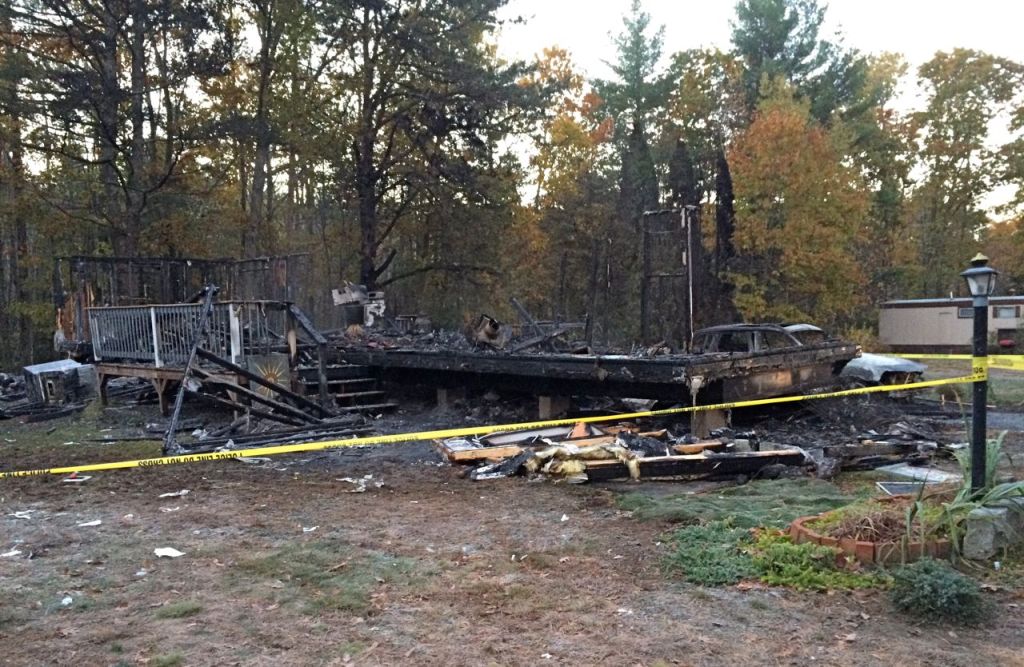 The charred frames of two walls and the porch stairs were the only identifiable pieces of the house remaining Tuesday morning. <em>Photo by Gillian Graham/Staff Writer</em>