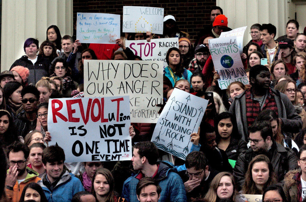 Colby College students and staff assemble on the steps of Miller Library after marching at the Waterville campus in a protest against certain policies espoused by President-elect Donald Trump.