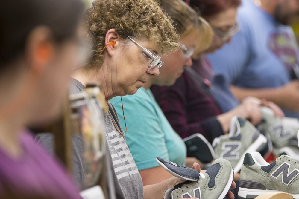 Deborah Brown inspects a completed shoe before it is boxed for shipping at New Balance's factory in Skowhegan in May. 