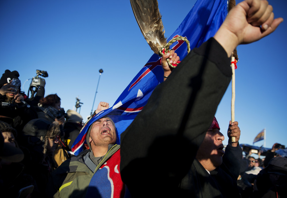 Members of a Native American drum procession celebrate at the Oceti Sakowin camp after it was announced that the U.S. Army Corps of Engineers won't grant easement for the Dakota Access oil pipeline in Cannon Ball, N.D., on Sunday.