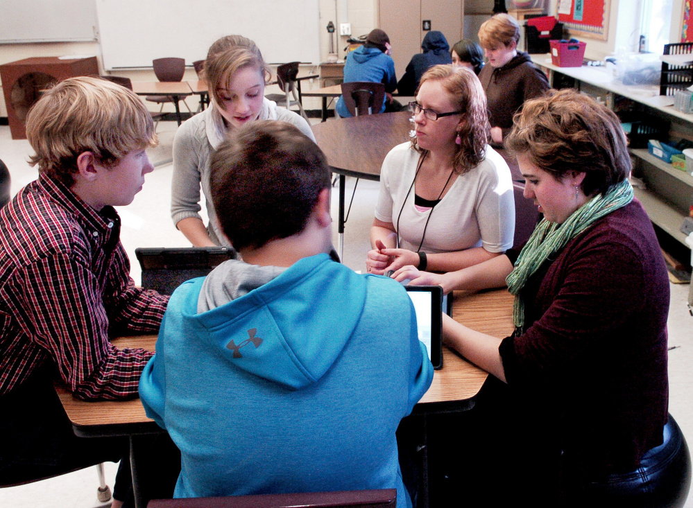 Cornville Regional Charter School teacher Ashlee Savage, second from right, speaks with students at the school on Tuesday, the same day that the school found out it has permission to expand from the existing kindergarten to eighth grade to pre-K through grade 12 next year. From left are Tyler Perry, Amber Savage, Ashlee Savage and Ayden Bosworth. Lydia Dore is in the foreground.