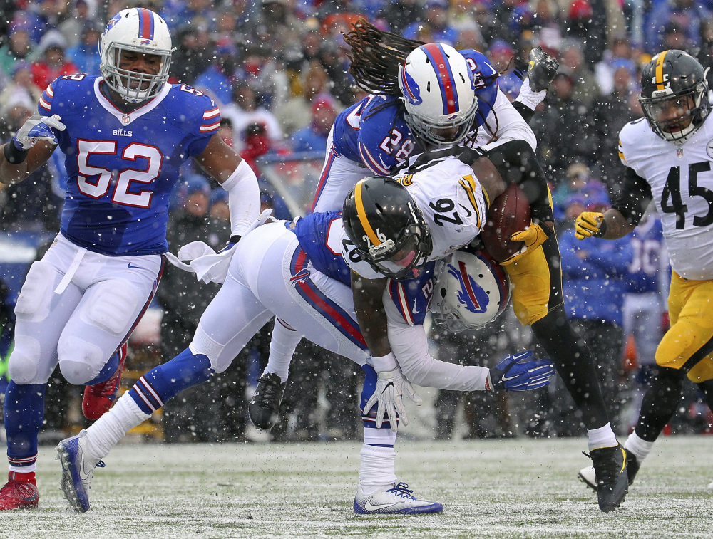 Steelers running back Le'Veon Bell is tackled by Buffalo's Ronald Darby, top, and Corey Graham during Sunday's game in Orchard Park, N.Y. Bell collected almost 300 yards rushing and receiving and scored all three Pittsburgh touchdowns in a 27-20 victory.