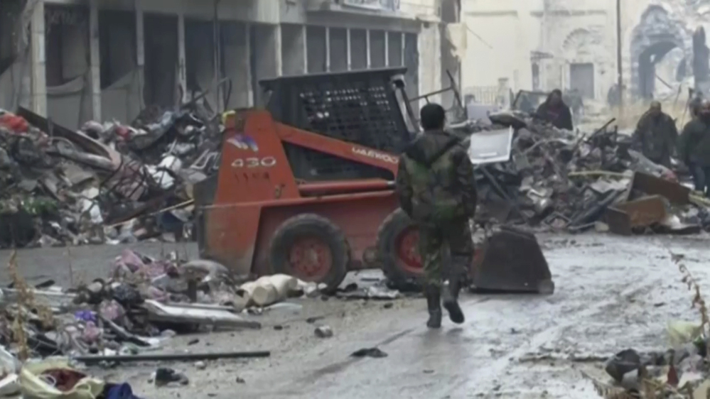 This image from a video on Tuesday shows Syrian soldiers walking among damaged buildings on a street filled with debris near the ancient Umayyad Mosque in the Old City of Aleppo, Syria.