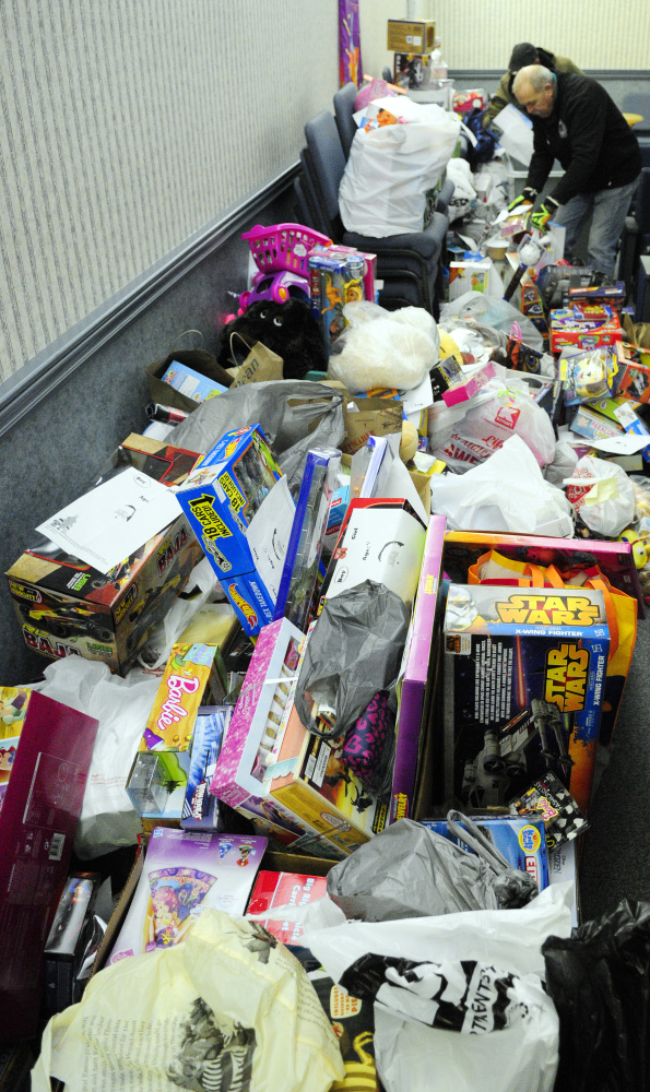 Volunteers from VA Maine Healthcare Systems-Togus unload toys donated by their colleagues Friday at the Salvation Army Capital Region center in Augusta.