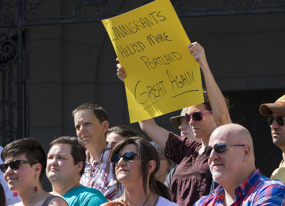 A protester presents her own version of Donald Trump's presidential campaign slogan Aug. 5, the day after he made disparaging remarks about Maine's Somali community. Attracting immigrants to Maine is critical to the revitalization of our aging, shrinking workforce.