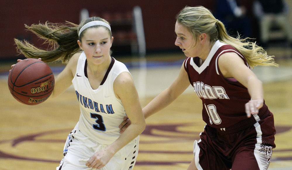 Windham's Mya Mannette drives against Lauren Young of Bangor during a Class AA North basketball game Friday in Windham. A big second-half rally by the hosts fell short, as Bangor earned its first win of the season, 36-34.