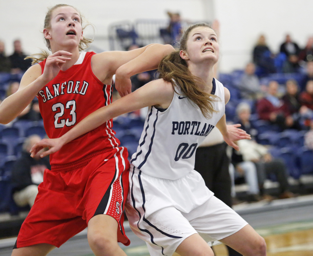 Rose Griffin of Portland boxes out Sanford freshman Paige Cote while preparing to pull down a rebound Tuesday during Sanford's 50-37 victory at the Portland Expo. Cote finished with 15 points and 10 rebounds.