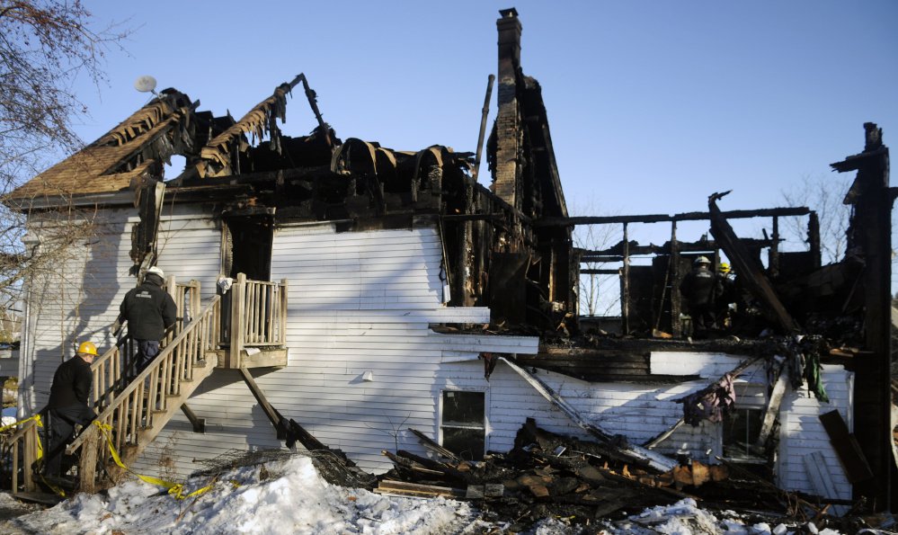 Investigators from the Fire Marshal's Office examine the ruins of a building that burned in Richmond on Sunday.