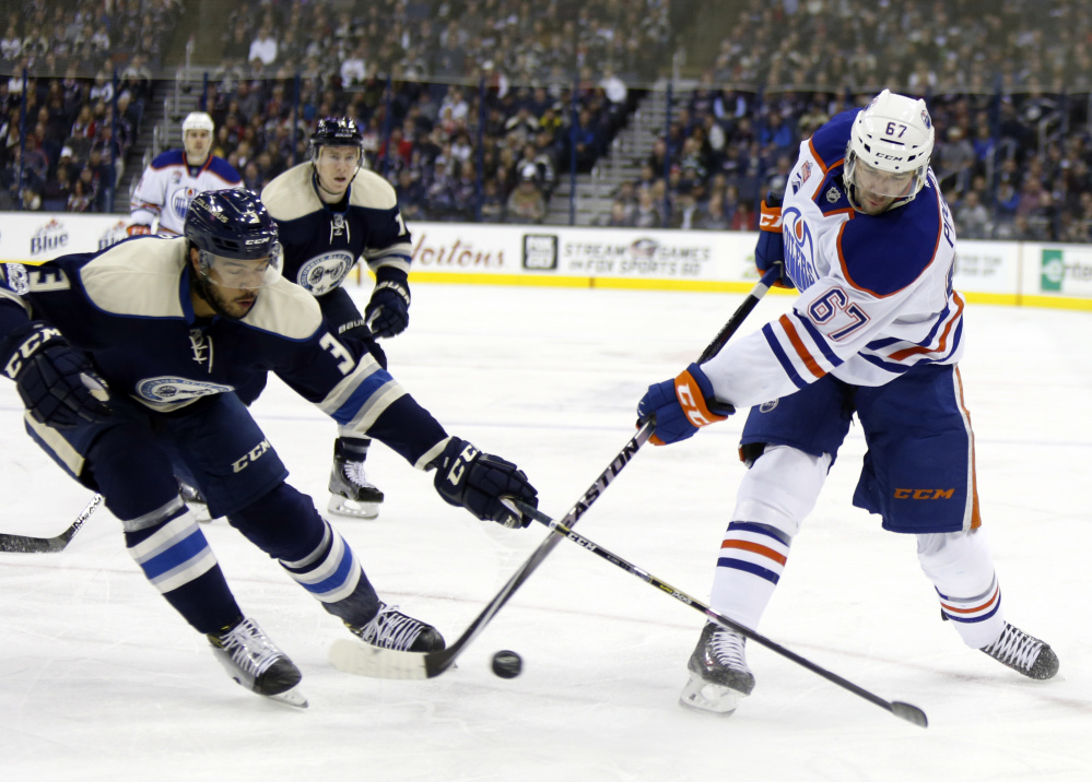 Edmonton's Benoit Pouliot, right, battles for the puck with Columbus defenseman Seth Jones in Tuesday's game at Columbus, Ohio. The Blue Jackets won their 16th straight, one shy of the NHL record.