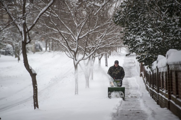 Daniel Mitchell operates a snowblower along the sidewalk on Norfolk Ave. next to Randolph College on Saturday, Jan. 7, 2017 in Lynchburg, Va. (Jay Westcott  /News & Daily Advance via AP)