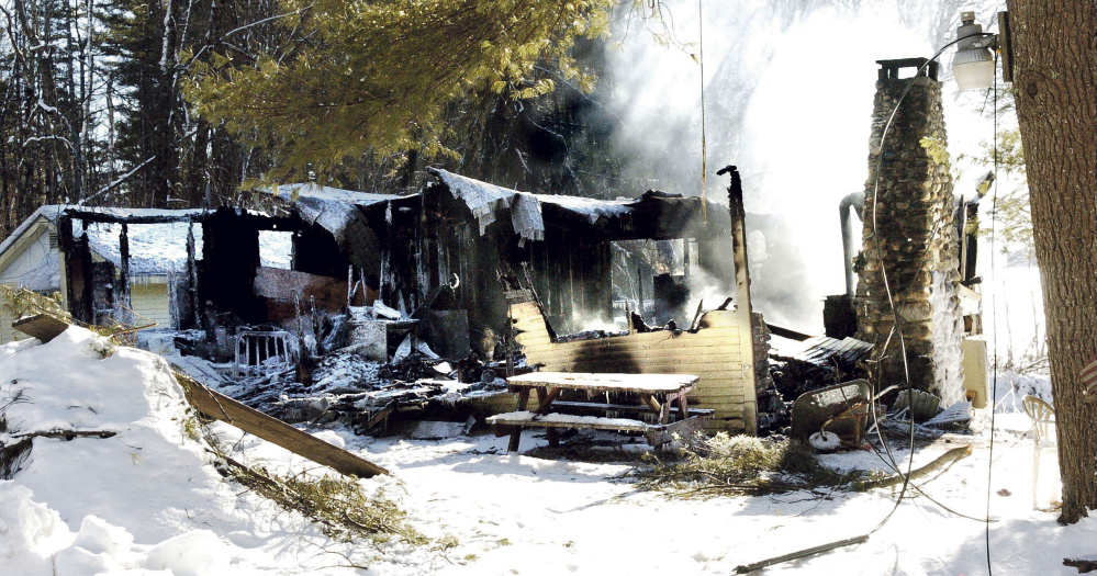 Smoke rises Sunday from the remains of a house on Washington Boulevard in China, where the owner, Randall Luck, was found dead Sunday morning outside the home.