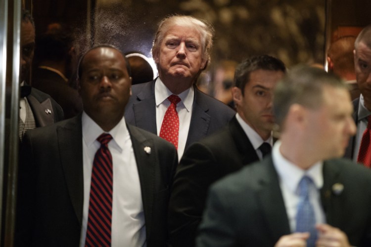 President-elect Donald Trump gets on an elevator after speaking with reporters at Trump Tower in New York Monday. Hearings for Trump's cabinet nominees are scheduled to begin Tuesday.