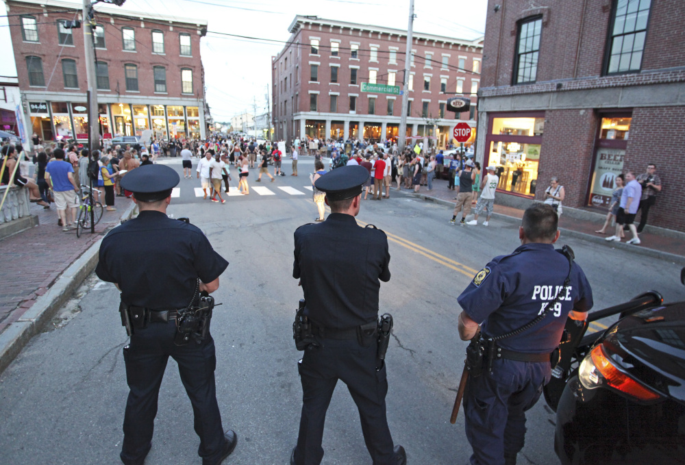 Police keep their distance on Pearl Street as about 150 people rally on Commercial Street in Portland for a July 15, 2016 Black Lives Matter event. 