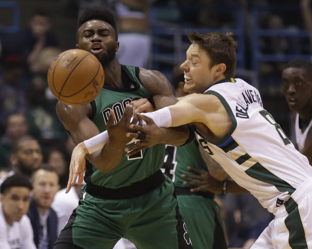 Milwaukee's Matthew Dellavedova, right, knocks the ball away from Boston's Jaylen Brown during the Celtics' 112-108 overtime win Saturday night.